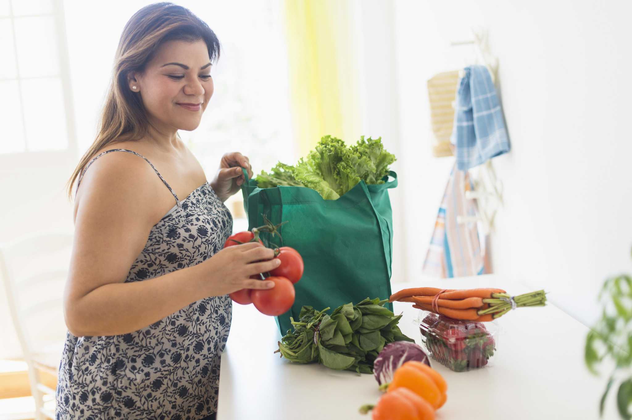 USA, New Jersey, Jersey City, Woman taking out vegetables of grocery bag